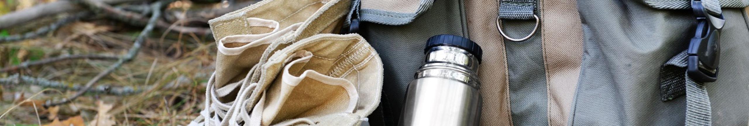 Schoenen, drinkfles en rugzak in de natuur