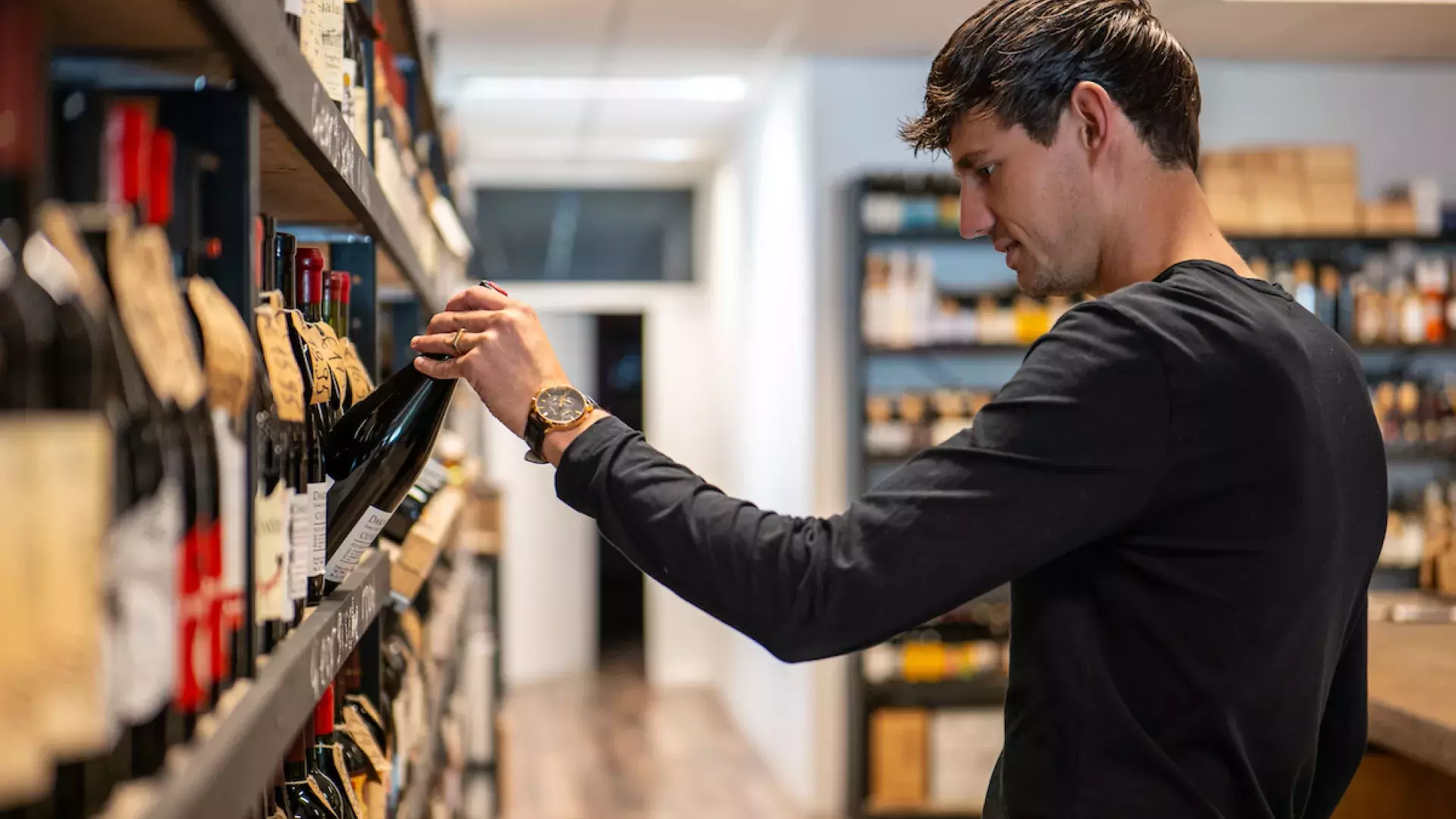 Klant bij winkelschap met wijn